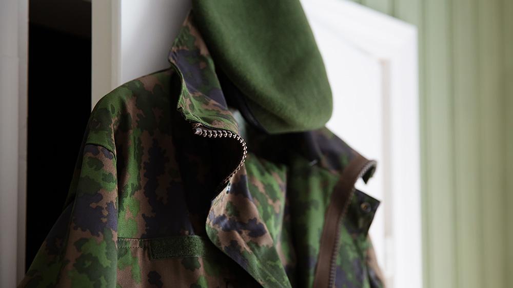 Army clothes hang on the door frame.